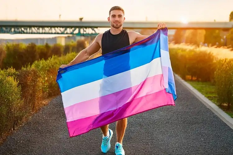 Person holding a transgender flag outdoors