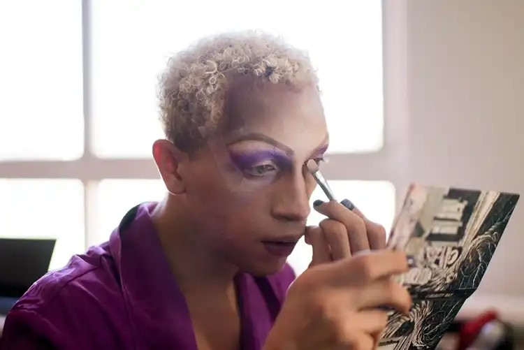 Person applying makeup backstage in a candid moment