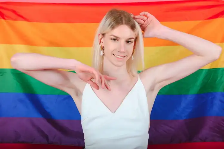 Transgender woman holding a pride flag against a colorful background